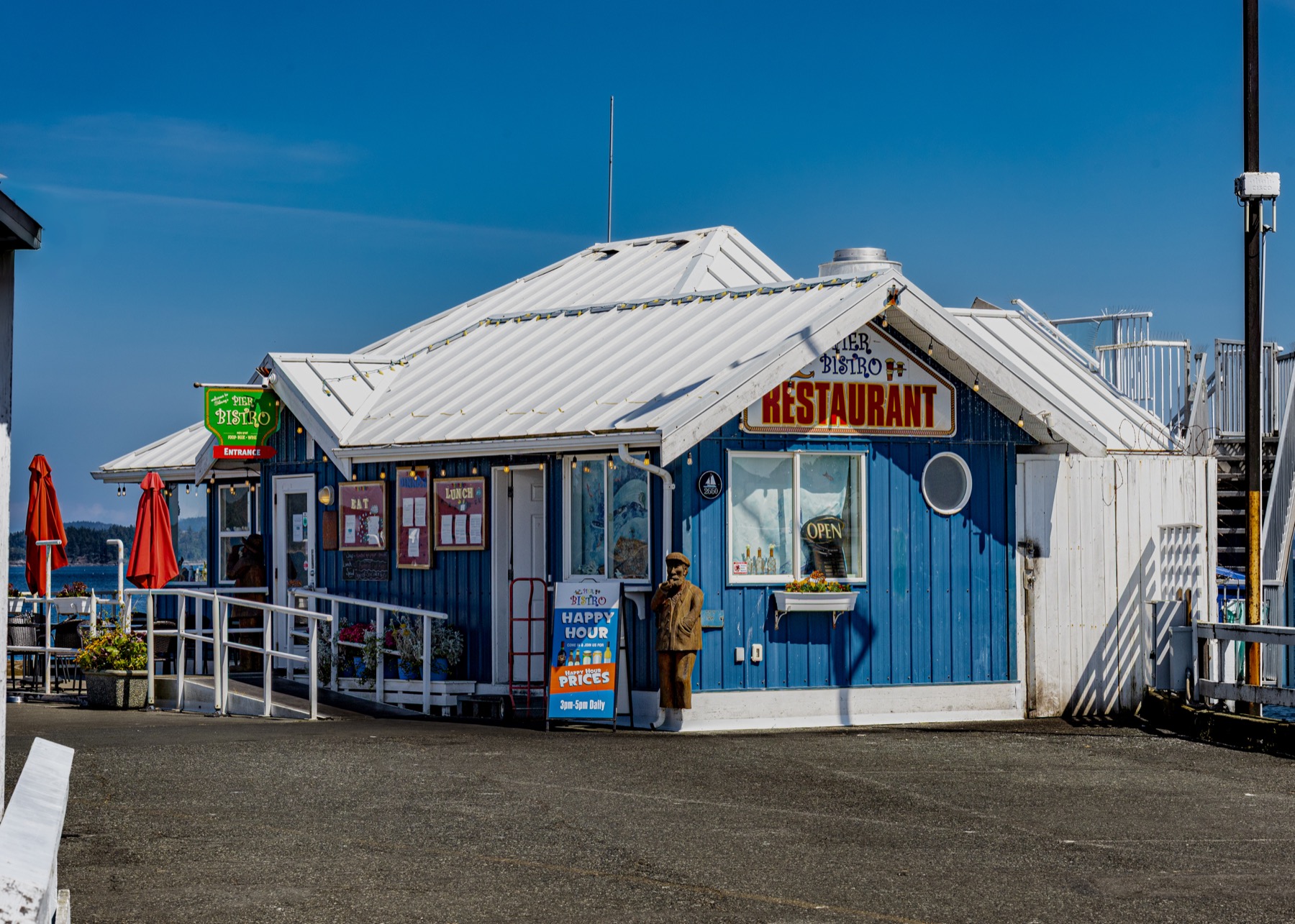 The Pier Bistro exterior with blue siding and white roof on a sunny day.