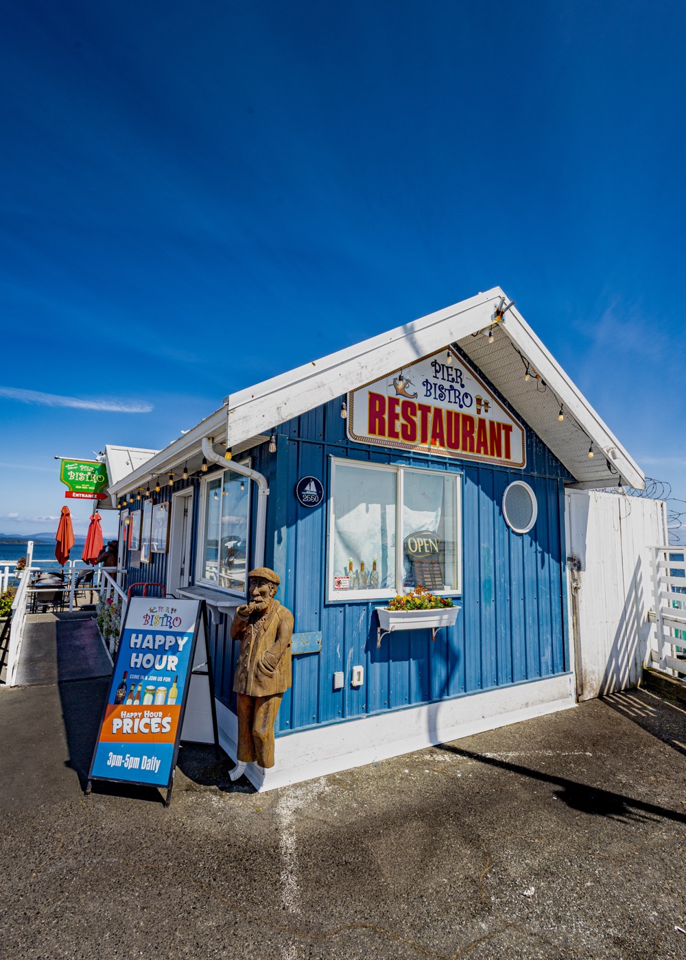Side view of The Pier Bistro building and patio umbrellas.